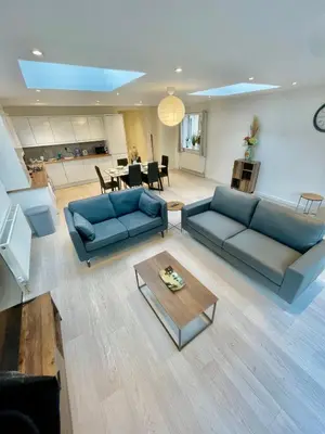 a living room with a blue couch and a table at beautiful 3 bedroom apartment in cambridge sleeps 7 in Milton