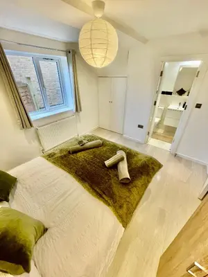 a bedroom with a large bed with a green blanket at beautiful 3 bedroom apartment in cambridge sleeps 7 in Milton