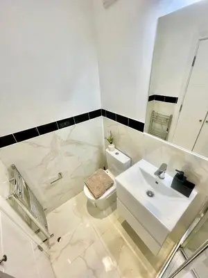 a white bathroom with a sink and a toilet at beautiful 3 bedroom apartment in cambridge sleeps 7 in Milton