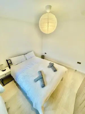 a bedroom with a large bed with a pendant light at beautiful 3 bedroom apartment in cambridge sleeps 7 in Milton