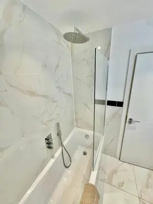 a white bathroom with a shower and a tub at beautiful 3 bedroom apartment in cambridge sleeps 7 in Milton