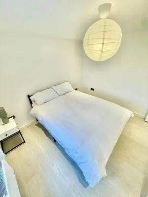 a bedroom with a large white bed and a lamp at Modern 2 bedroom apartment in cambridge in Milton