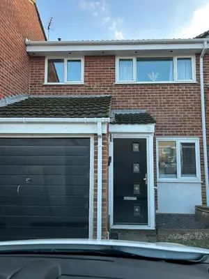 a garage with a black door and a brick house at Spacious 3BR Home in Colchester, with Private Parking in Colchester