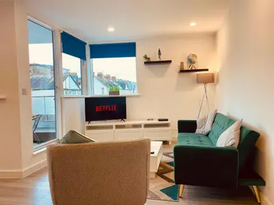 a living room with a couch and a tv at Central Leigh, on the Broadway, private gated parking, balcony in Southend-on-Sea