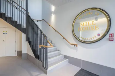 a lobby with stairs and amill house sign on the wall at Superb Central Apt River Views & Parking in Cambridge