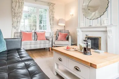 a living room with a couch and a fireplace at Milestone House, Aldeburgh in Aldeburgh
