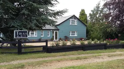 a blue house with a sign in front of it at Tirah Guest House in Aldeburgh