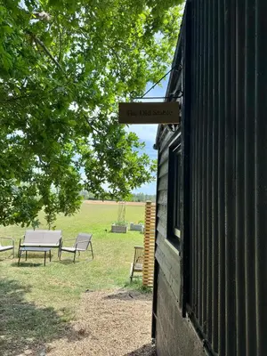 a sign on the side of a building with two benches at The Old Stable 1 in Messing