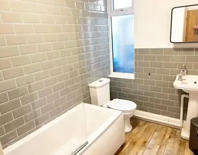 a bathroom with a tub and a toilet and a sink at Leigh On Sea -Broadway-Two Bed with Garden in Southend-on-Sea