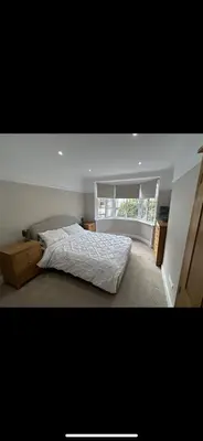 a bedroom with a bed and a large window at Leigh On Sea -Broadway-Two Bed with Garden in Southend-on-Sea