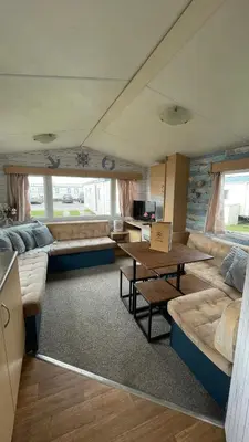 a living room with couches and a table at Adventure Van 6 berth St Osyth Beach Park in Saint Osyth