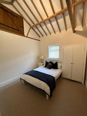 a bedroom with a large bed in a room at character filled barn renovation in Old Hurst