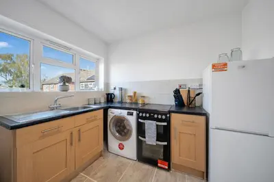 a kitchen with a sink and a washing machine at Chic Colchester Flat in Colchester