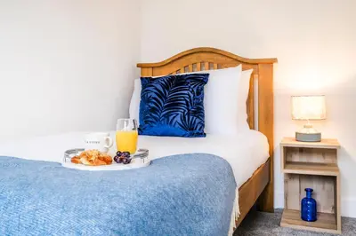 a bedroom with a bed with a tray of orange juice at 2 Bed Elegant home with Parking in Harlow in Harlow