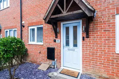 a brick house with a white door and a brick wall at 2 Bed Elegant home with Parking in Harlow in Harlow