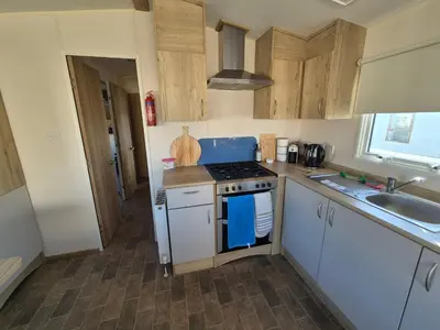 a small kitchen with a stove and a sink at 3 Bedroom 2 Bathroom Caravan Charlie Delta in Saint Osyth