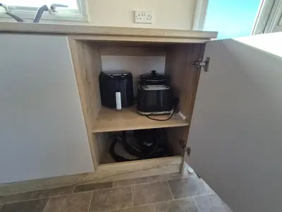 a kitchen cupboard with a slow cooker in it at 3 Bedroom 2 Bathroom Caravan Charlie Delta in Saint Osyth