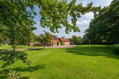 a house in the middle of a grassy yard at Belchamp Hall Hayloft in Belchamp Otten