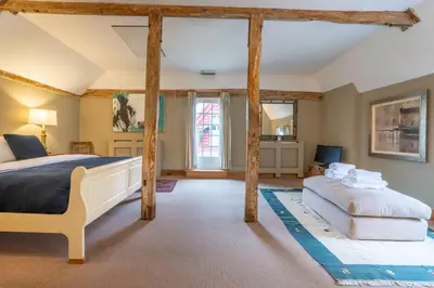 a bedroom with a large bed and a couch at Belchamp Hall Coach House in Belchamp Otten