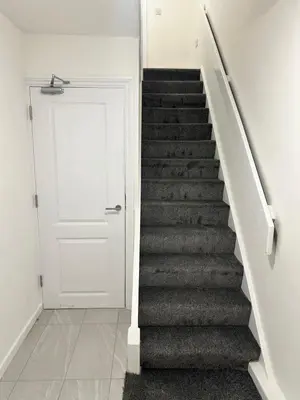 a stairway with a white door and a white staircase at Basildon Everlight Villa in Basildon