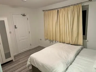 a bedroom with a white bed and a window at Basildon Everlight Villa in Basildon