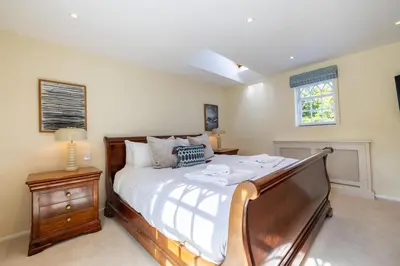 a bedroom with a large bed and a night stand at The Cat House in Woolverstone