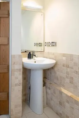 a bathroom with a white sink and a mirror at Emeny Cottage - Aldeburgh Coastal Cottages in Aldeburgh