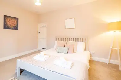 a bedroom with a white bed with two pillows at 7 Prospect Place - Aldeburgh Coastal Cottages in Leiston
