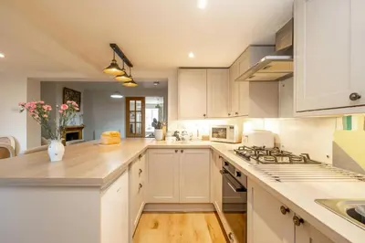 a kitchen with white cabinets and a counter top at 7 Prospect Place - Aldeburgh Coastal Cottages in Leiston