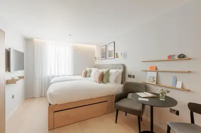 a bedroom with a bed and a table and a chair at Wilde Cambridge City Centre in Cambridge