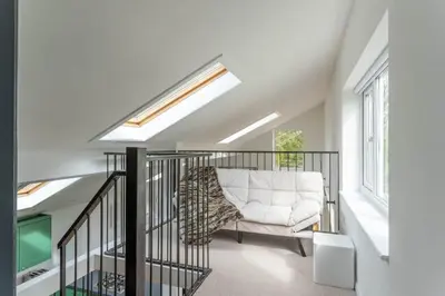 a living room with a white couch on a balcony at Luxury self contained one bedroom - Sawbridgeworth in Sheering