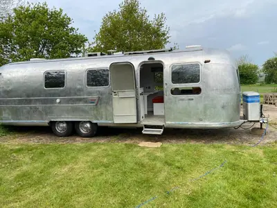 a silver airstream trailer parked in a field at Bury - Lodge - Sleeps 2 - Parking in Great Welnetham