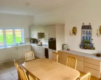 a kitchen with a wooden table and a table and chairs at North Farm fits 1-6 people in Sawston