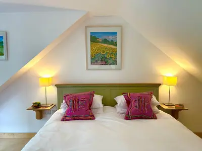 a bedroom with a bed with two pink pillows at Crown Lodge, Great Glemham in Saxmundham
