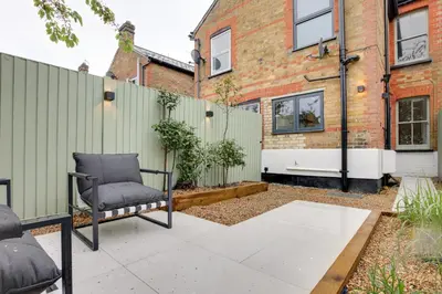 a patio with a chair and a fence at Luxury Two Bedroom Cottage - Bishops Stortford in Bishops Stortford