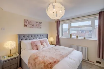 a bedroom with a large bed and a window at Luxury - 4 BHK Semi Detached House in Chelmsford