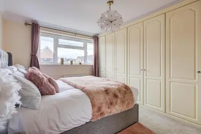 a bedroom with a large bed with a large window at Luxury - 4 BHK Semi Detached House in Chelmsford