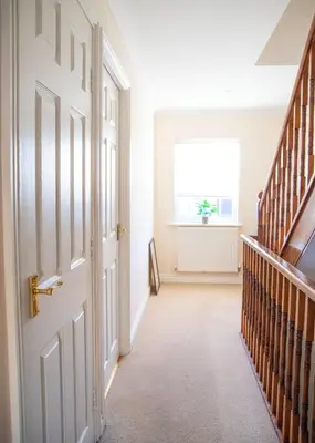 an empty hallway with a door and a window at 4x Bed Elegant Home with Parking in Ely
