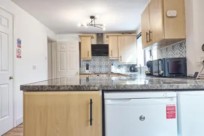 a kitchen with wooden cabinets and a counter top at 4br 2bath House With Free Parking In Rivenhall in Rivenhall