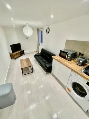 a living room with a couch and a microwave at cozy 1 bedroom flat near cambridge city centre in Milton