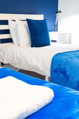 two beds with blue and white pillows in a bedroom at 2br 2bath Flat In Ipswich City Centre - 6 Guests in Ipswich