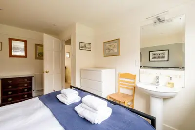a bedroom with a bed and a sink at 8 Lee Road, Aldeburgh - Aldeburgh Coastal Cottages in Aldeburgh