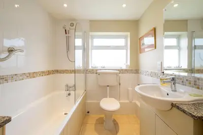 a bathroom with a sink and a toilet and a tub at 8 Lee Road, Aldeburgh - Aldeburgh Coastal Cottages in Aldeburgh