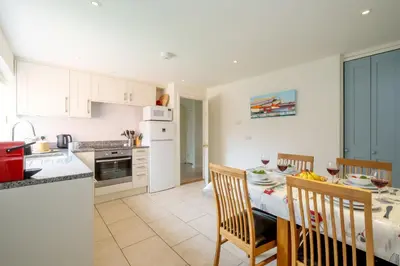 a kitchen and dining room with a table and chairs at 8 Lee Road, Aldeburgh - Aldeburgh Coastal Cottages in Aldeburgh