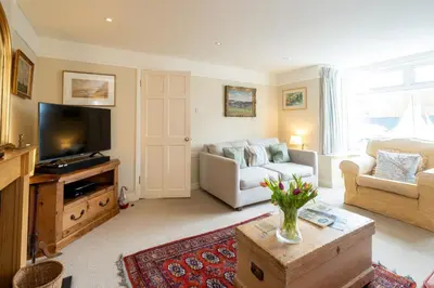 a living room with a couch and a tv at 8 Lee Road, Aldeburgh - Aldeburgh Coastal Cottages in Aldeburgh