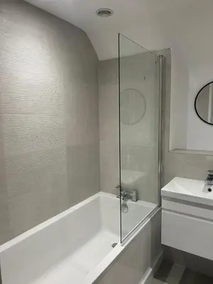 a bathroom with a shower and a tub and a sink at Mango Cottage in Thorndon