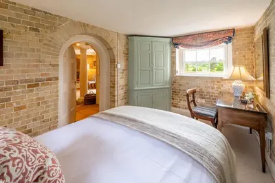 a bedroom with a bed and a desk and a window at A Duke's Spectacular grand folly - The Temple in Euston