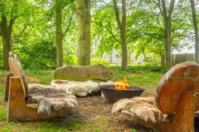 a group of dogs sitting around a fire in a park at A Duke's Spectacular grand folly - The Temple in Euston