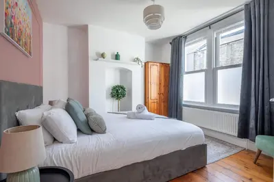 a bedroom with a large bed and a window at Stylish 3-Bed Home in the Heart of the Cambridge in Cambridge