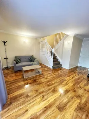 a living room with a couch and wooden floors at Modern 3 Bed House In Essex By DLuxoria Short Lets & Serviced Accommodation With Pet Friendly, Free WiFi & Free Parking in Basildon